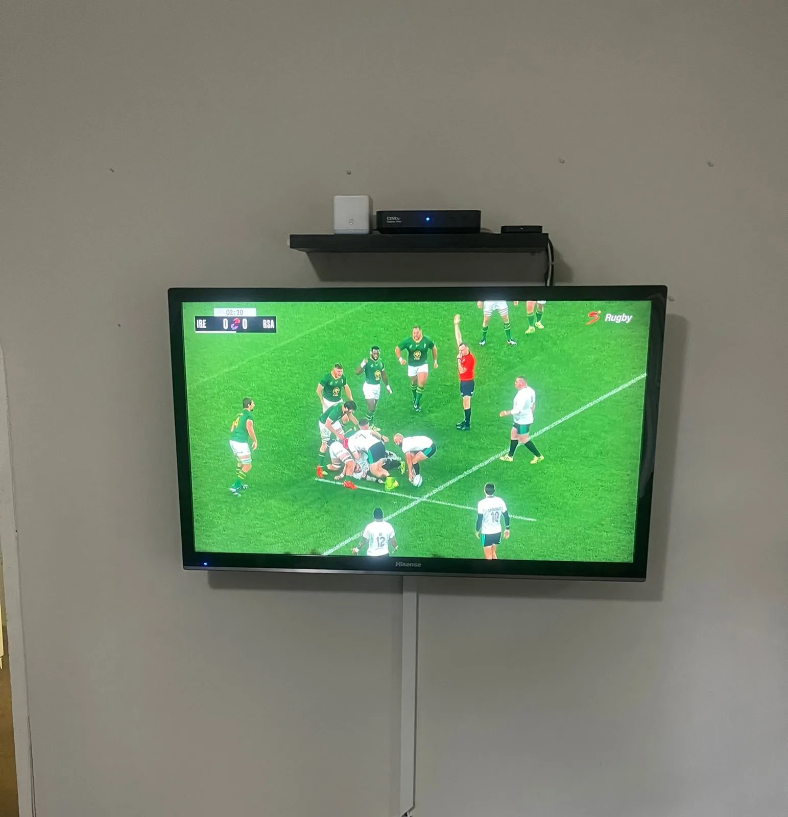 DSTV Explora decoder beside a wall-mounted lounge TV